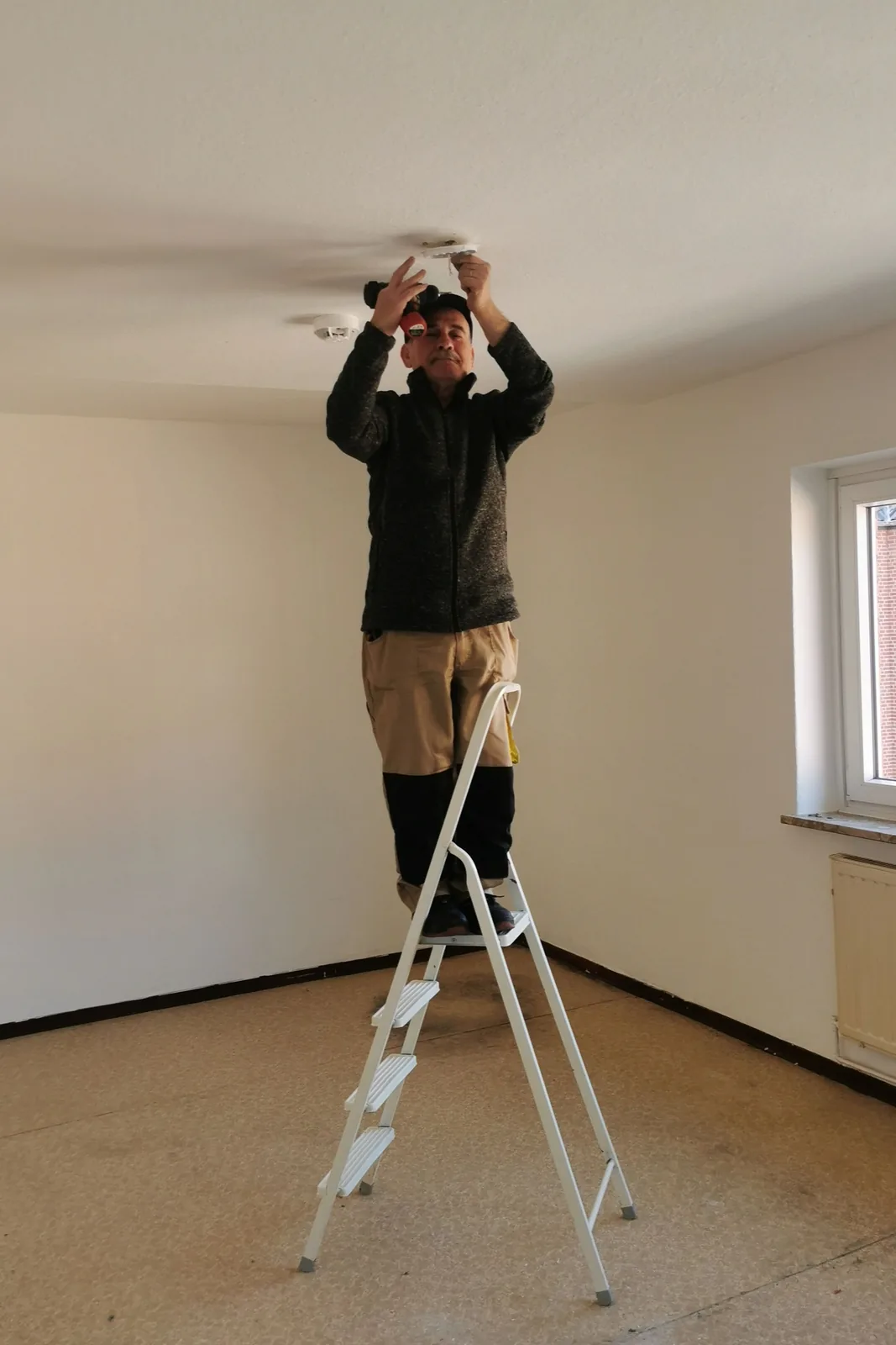 Fitting a ceiling detector from a step ladder, for ceiling fan installation in Oklahoma City